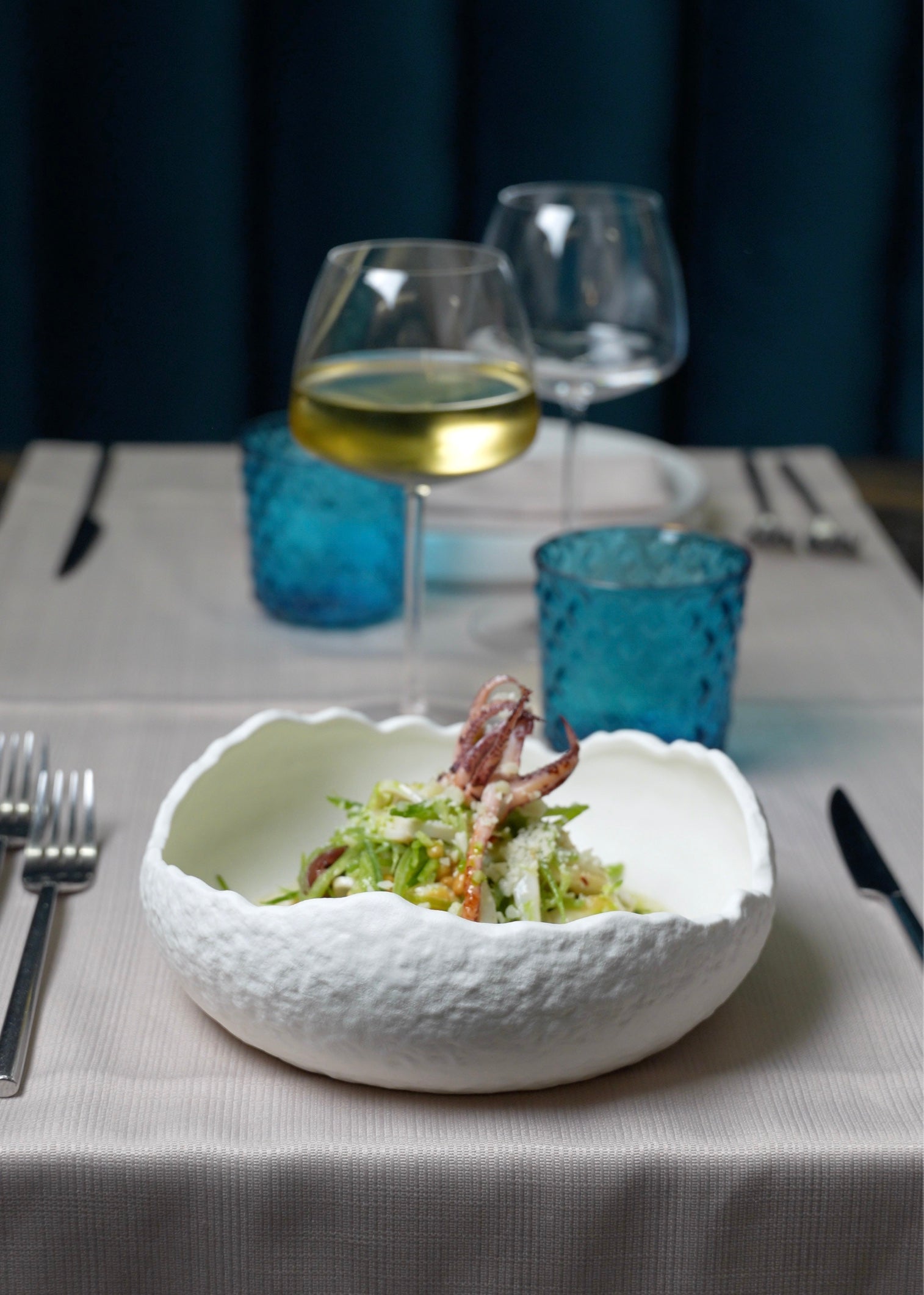 Tavolo con calice di vino e piatto gourmet da Angelina